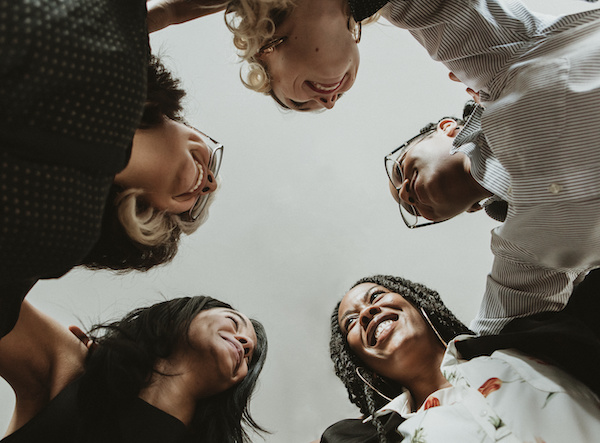 Happy diverse businesswomen huddling in the office